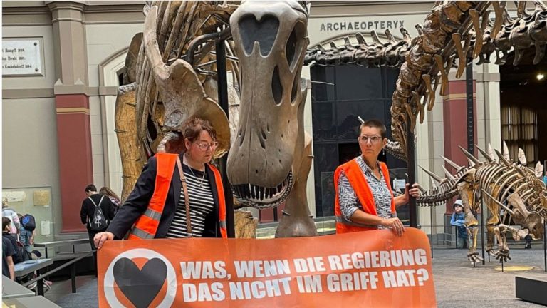 German climate activists glue themselves to dinosaur display