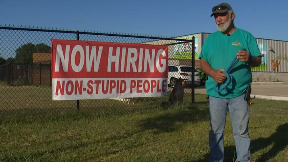 Business owner standing in front of controversial sign