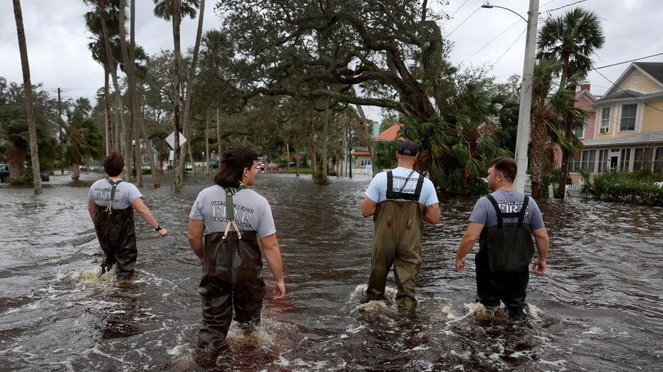 Florida men stand amidst flooding from Nicole