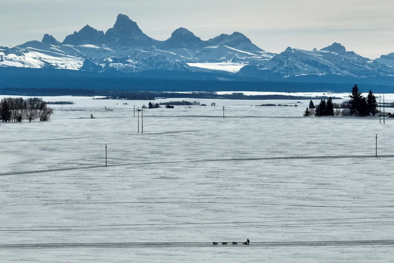 A musher races their six-dog team past the Teton Range during the first day of the 106th American Dog Derby on February 17, 2023 in Ashton, Idaho. (Photo by Steph Chambers/Getty Images)