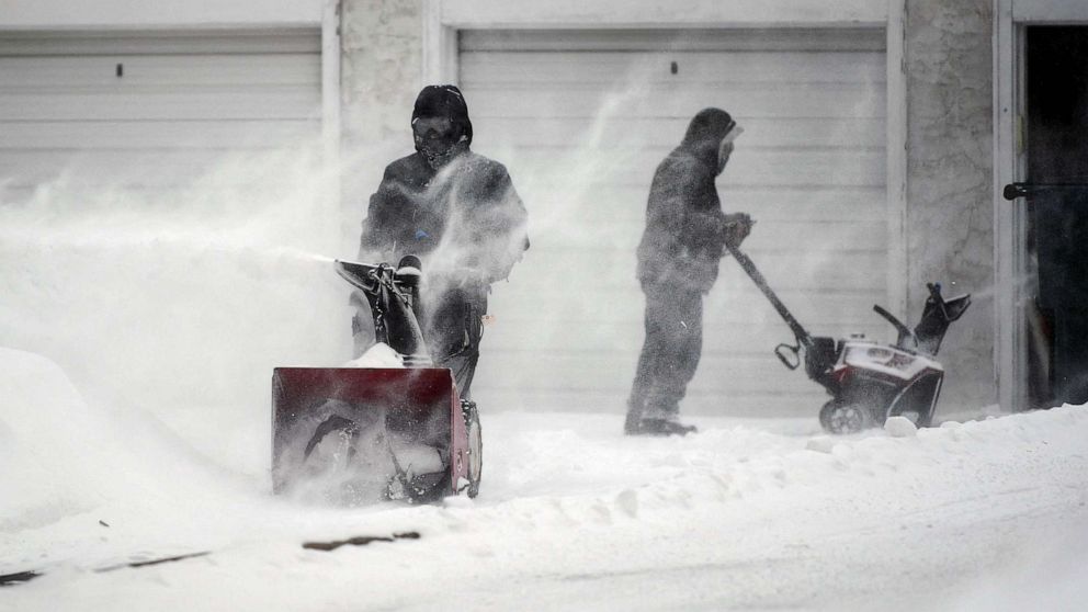 PHOTO: People clear snow from a driveway during a snowstorm in Minneapolis, Feb. 22, 2023.