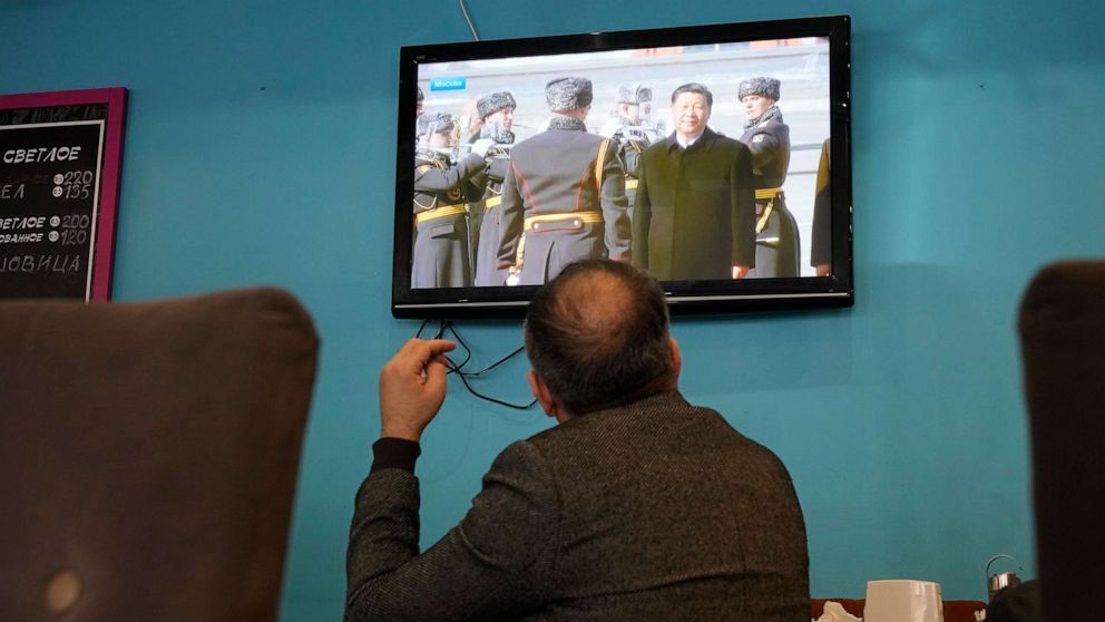 PHOTO: A TV screen displays Chinese President Xi Jinping attending an official welcome ceremony upon his arrival at the Vnukovo-2 government airport outside Moscow, in a cafe in St. Petersburg, Russia, Monday, March 20, 2023.