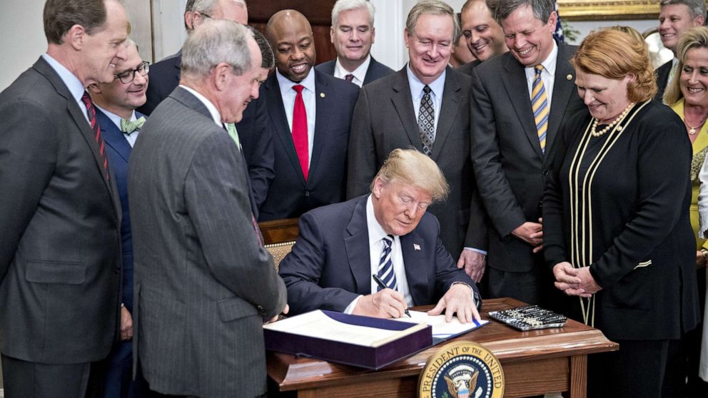 PHOTO: President Donald Trump signs S. 2155, the Economic Growth, Regulatory Relief, And Consumer Protection Act, with administration officials and members of Congress in Washington, May 24, 2018.