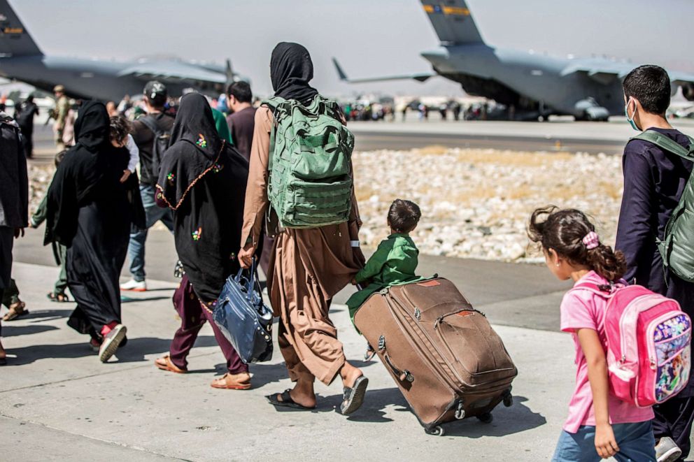 PHOTO: In this Aug. 24, 2021, file photo, provided by the U.S. Marine Corps, families walk towards their flight during ongoing evacuations at Hamid Karzai International Airport, in Kabul, Afghanistan.