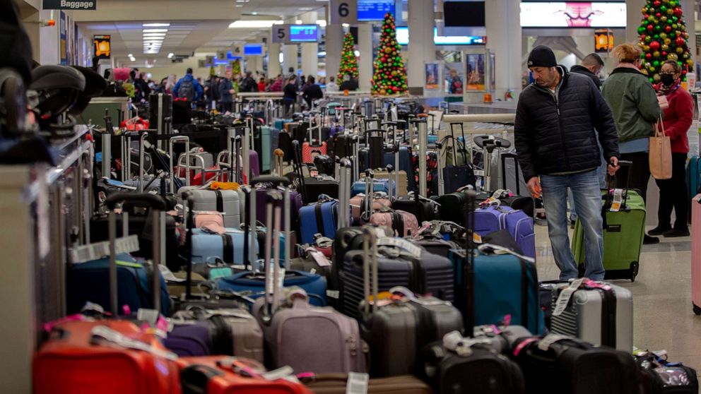 PHOTO: Stranded travelers search for their luggage at the Southwest Airlines Baggage Claim at Midway Airport on Dec. 27, 2022 in Chicago.