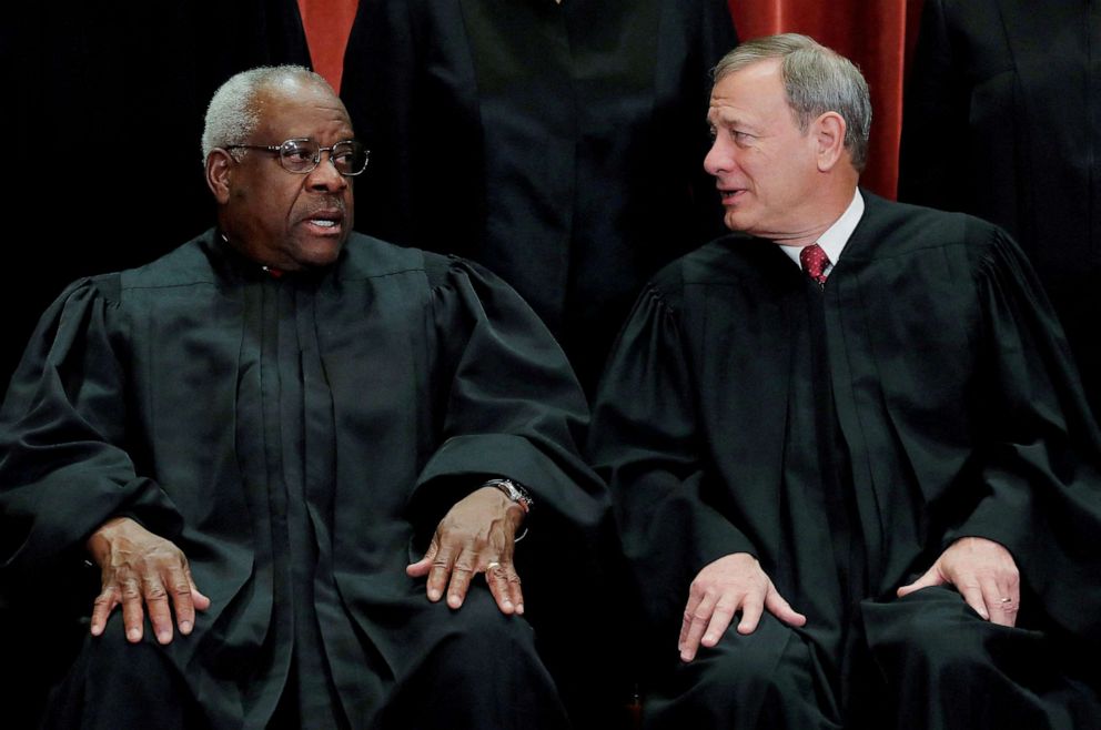 PHOTO: Supreme Court Associate Justice Clarence Thomas talks with Chief Justice John Roberts during the group portrait session at the Supreme Court in Washington, D.C., Nov. 30, 2018.