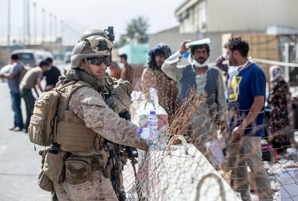 PHOTO: Marines with Special Purpose Marine Air-Ground Task Force-Crisis Response-Central Command provide assistance during an evacuation at Hamid Karzai International Airport, in Kabul, Afghanistan, Aug. 21.
