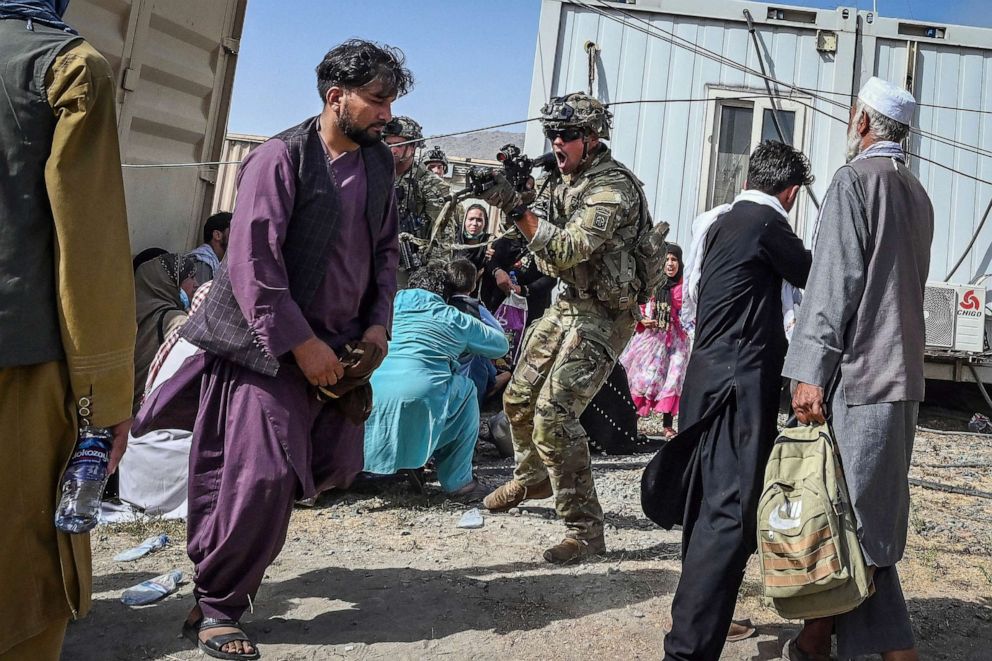 PHOTO: FILE - A US soldier point his gun towards an Afghan passenger at the Kabul airport in Kabul, Aug. 16, 2021, after a stunningly swift end to Afghanistan's 20-year war.