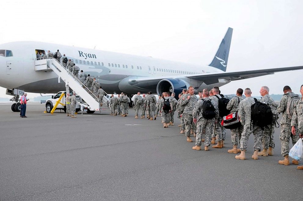 PHOTO: Members of the 218th Maneuver Enhancement Brigade wait on the Charleston tarmac before departing for annual training in 2010.