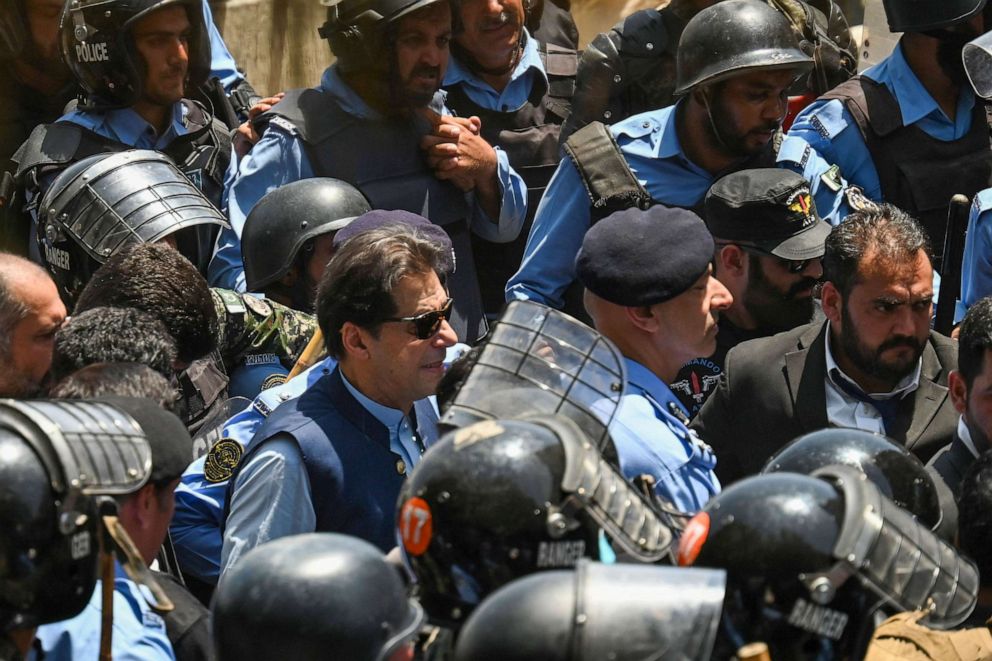 PHOTO: Policemen escort Pakistan's former Prime Minister Imran Khan (C) as he arrives at the high court in Islamabad on May 12, 2023.