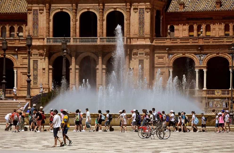 PHOTO: A group of school children cool off walking along a fountain at the Plaza Espana square in Seville on April 26, 2023 as Spain is bracing for an early heat wave.