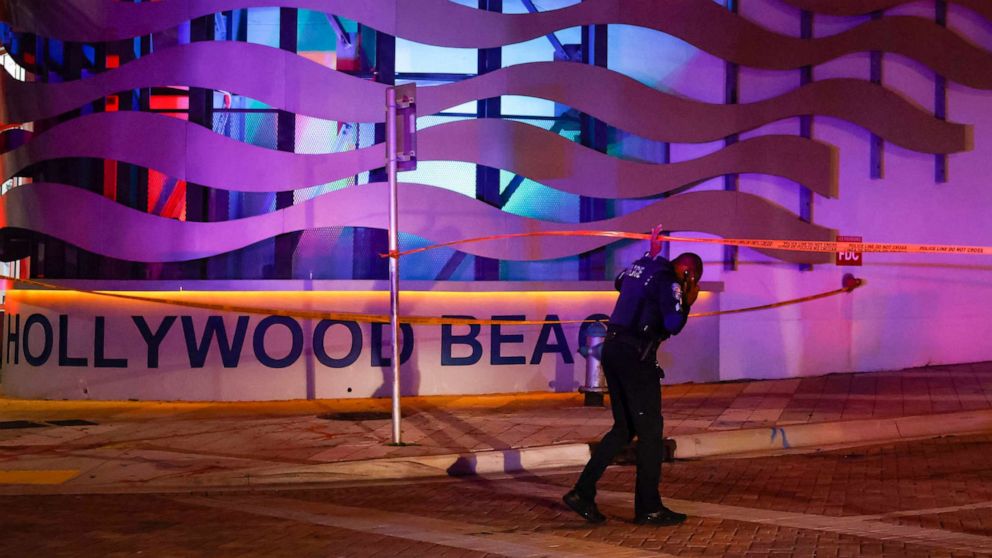 PHOTO: An officer passes through a crime scene tape cordon along a street as they respond to a shooting at Hollywood Beach, May 29, 2023 in Hollywood, Florida.