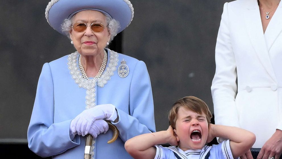 PHOTO: Britain's Prince Louis of Cambridge holds his ears as he stands next to Queen Elizabeth II to watch a flypast from Buckingham Palace balcony, as part of Queen Elizabeth II's platinum jubilee celebrations, in London, June 2, 2022.