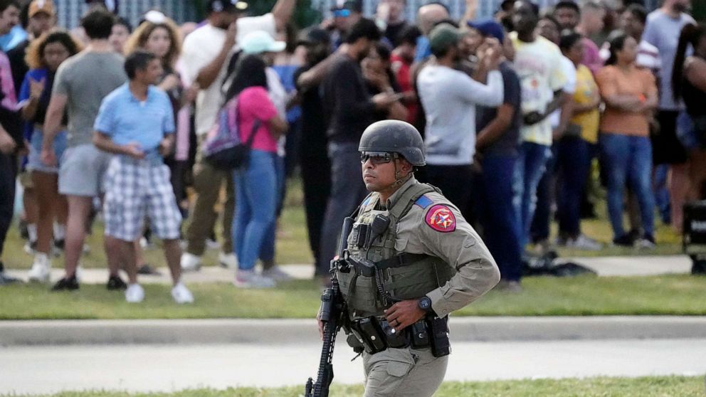 PHOTO: A law enforcement officer walks as people are evacuated from a shopping center where a shooting occurred, May 6, 2023, in Allen, Texas.