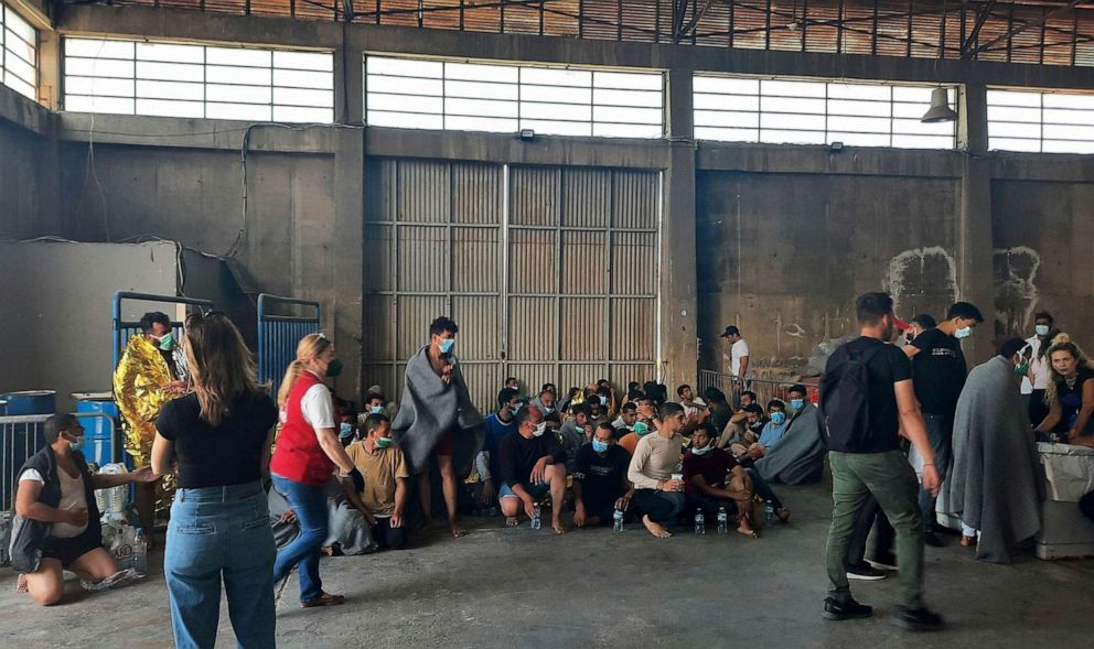 PHOTO: Survivors of a shipwreck sit in a warehouse, at the port in Kalamata town, southwest of Athens, Greece, on Wednesday, June 14, 2023.