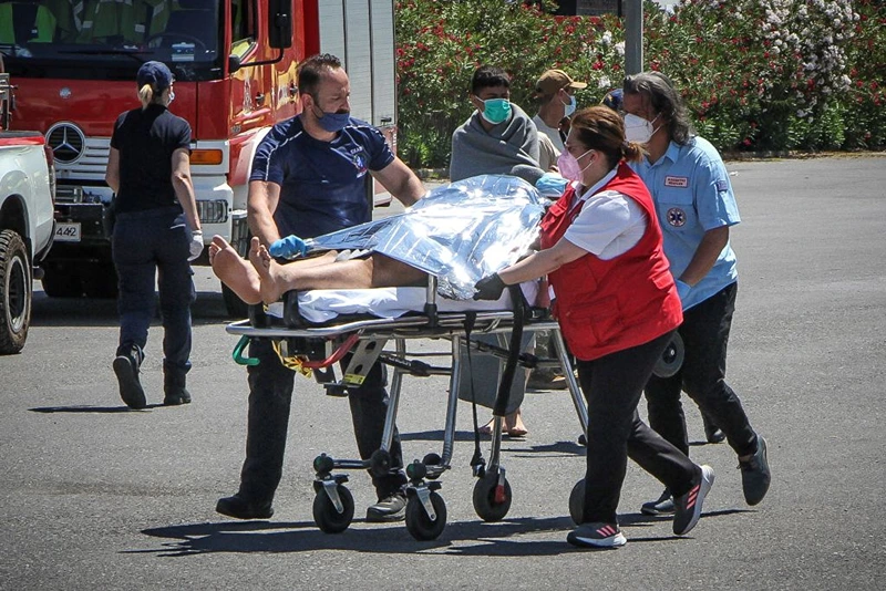 TOPSHOT - Medics carry a survivor on a stretcher, after a boat carrying dozens of migrants sank in international waters in the Ionian Sea, at the port in Kalamata town, on June 14, 2023. At least 59 people died while some 100 people were rescued after the boat capsized. (Photo by STRINGER / Eurokinissi / AFP) / Greece OUT (Photo by STRINGER/Eurokinissi/AFP via Getty Images)