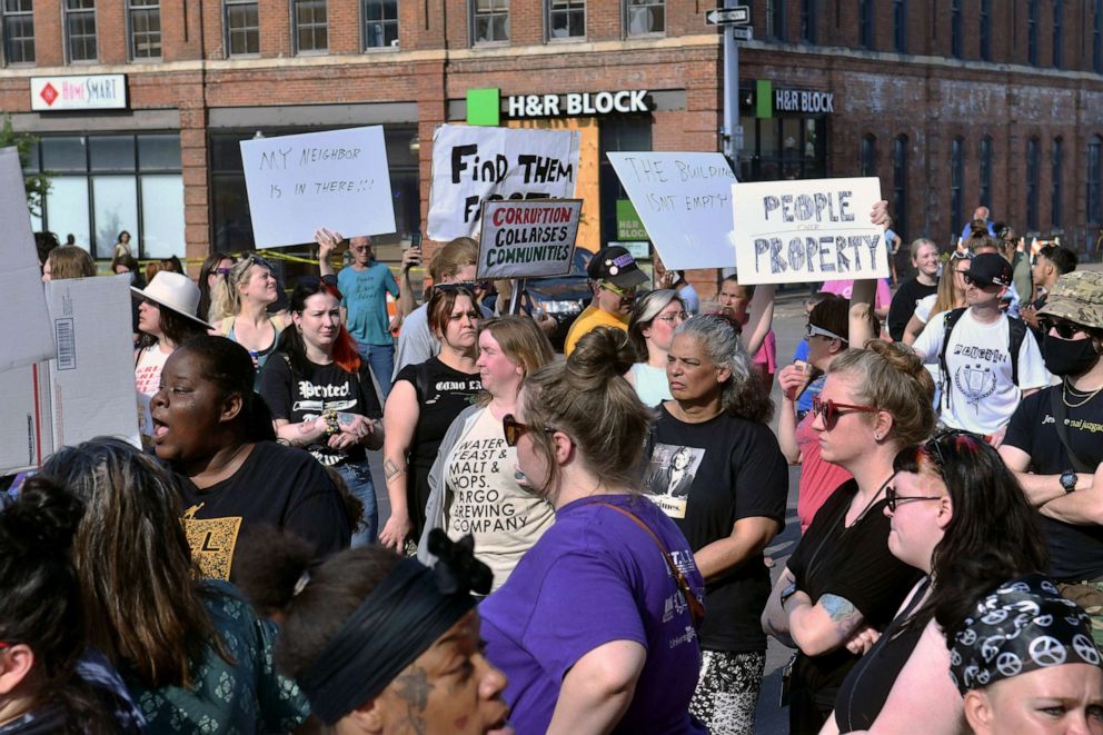 PHOTO: Protesters stand outside of Davenport City hall as rescuers enter the partially collapsed apartment building to remove tenants pets, May 30, 2023, in Davenport, Iowa.