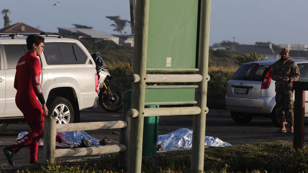 The bodies of two South Africa Navy personal lay covered after being recovered from the sea at Kommetjie, ear Cape own, South Africa, Wednesday, Sept. 20, 2023. The National Sea Rescue Institute (NSRI) said that two SA Navy divers were dead and five were rescued at sea just off the coast of Kommetjie. (AP Photo/Halden Krog)