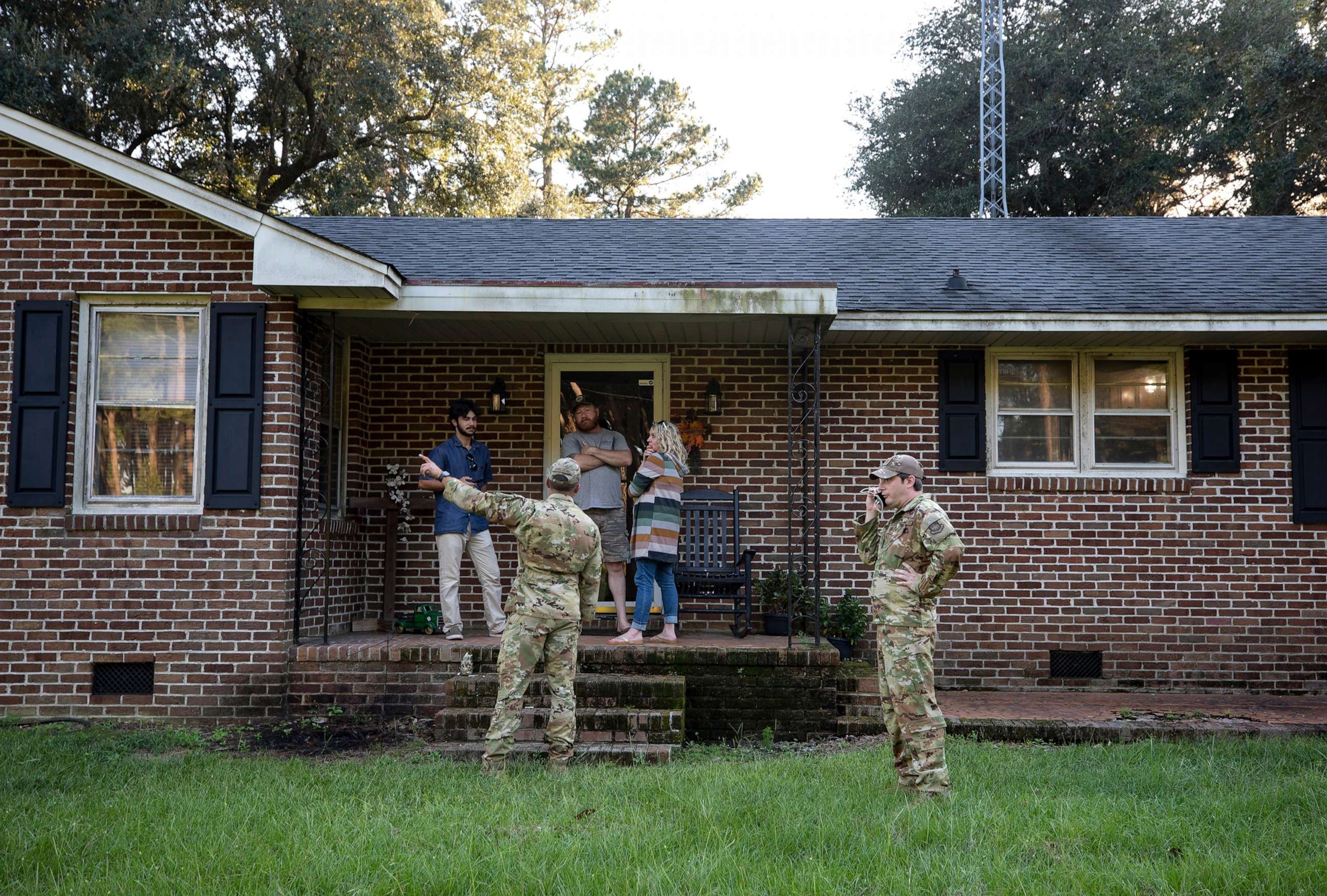 PHOTO: Airmen from Joint Base Charleston speak to a family living right next to the site of a crashed F-35 about the operation to recover the fighter jet and requests for the family in Williamsburg County, S.C., on Sept. 18, 2023.