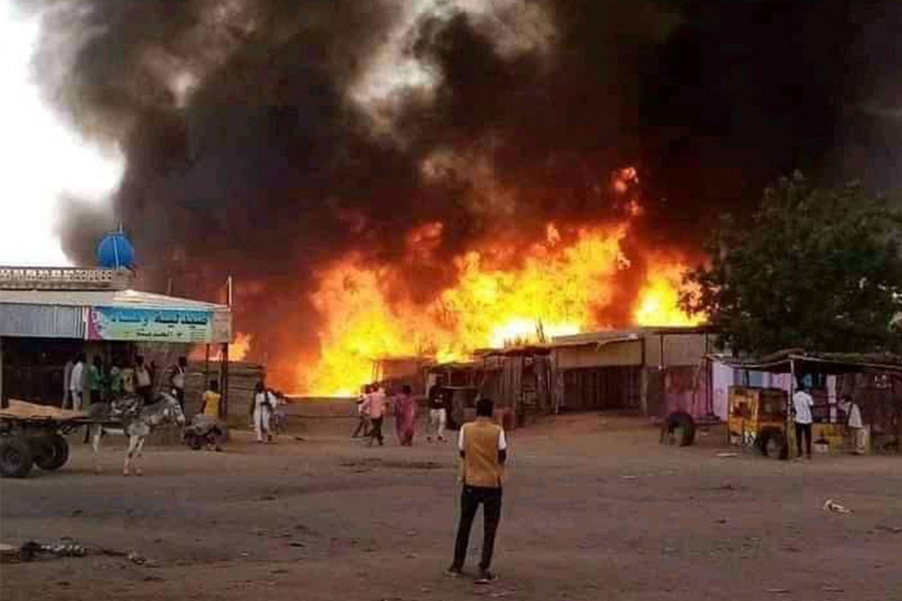PHOTO: A man stands by as a fire rages in a livestock market area in al-Fasher, the capital of Sudan's North Darfur state, on September 1, 2023, in the aftermath of bombardment by the paramilitary Rapid Support Forces (RSF).