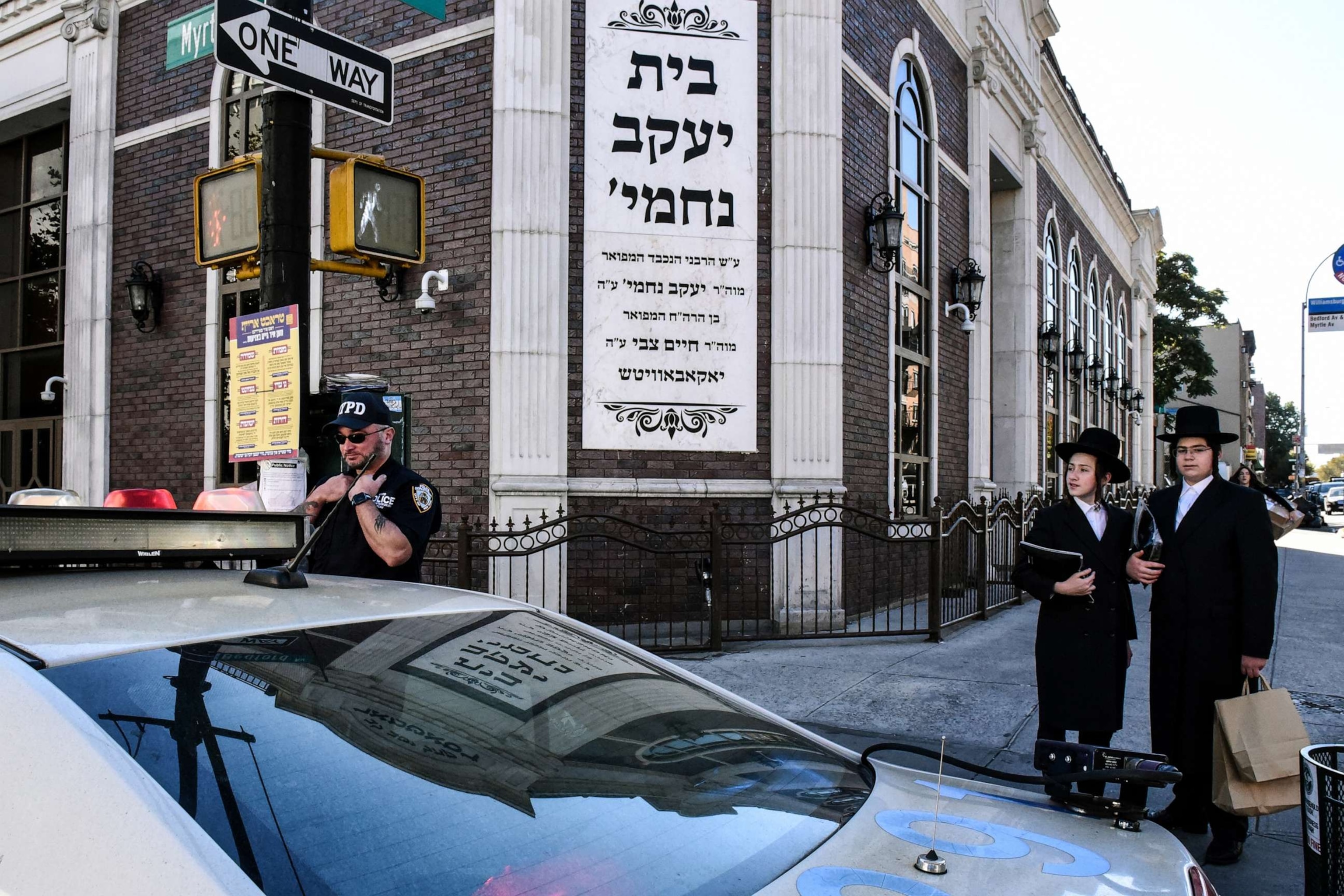 PHOTO: A member of the New York Police Department patrols in front of the synagogue Congregation Bais Yaakov Nechamia Dsatmar, Oct. 13, 2023, in Brooklyn.