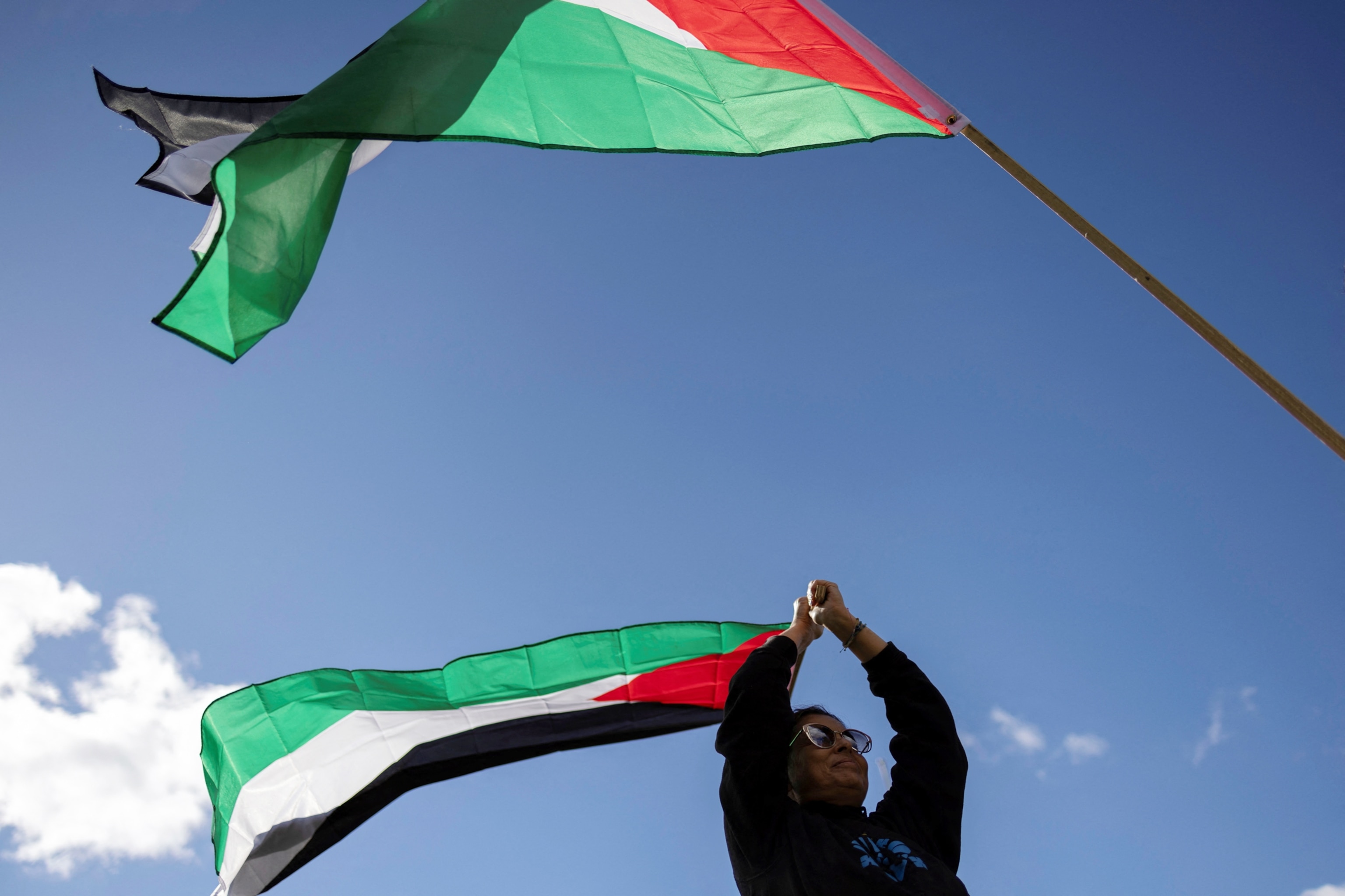 PHOTO: A woman holds a flag of Palestine during a rally held in support of Palestinians amid the ongoing conflict between Israel and the Palestinian Islamist group Hamas, in Mineola, N.Y., Oct. 15, 2023.