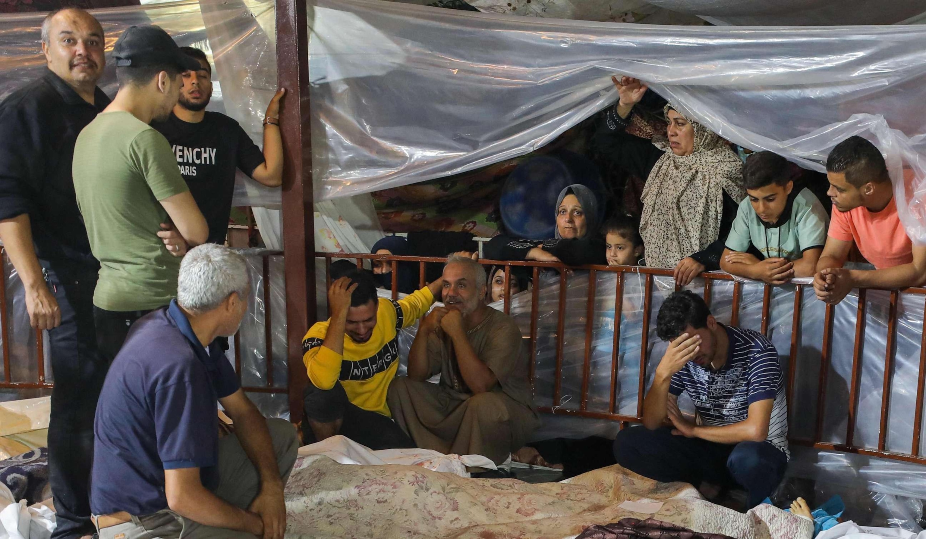 PHOTO: Relatives mourn over the bodies of Palestinians killed in an airstrike on the Ahli Arab hospital in central Gaza after they were transported to Al-Shifa hospital, October 17, 2023.