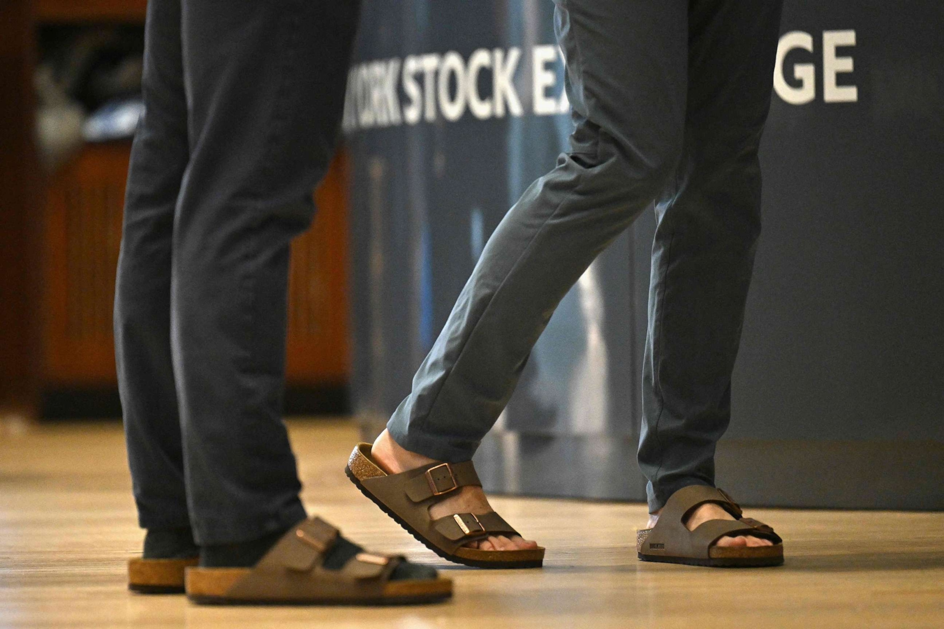 PHOTO: Traders are seen wearing Birkenstock sandals on the floor at the New York Stock Exchange (NYSE) in New York on Oct. 11, 2023, during Birkenstock's launch of an Initial Public Offering (IPO).