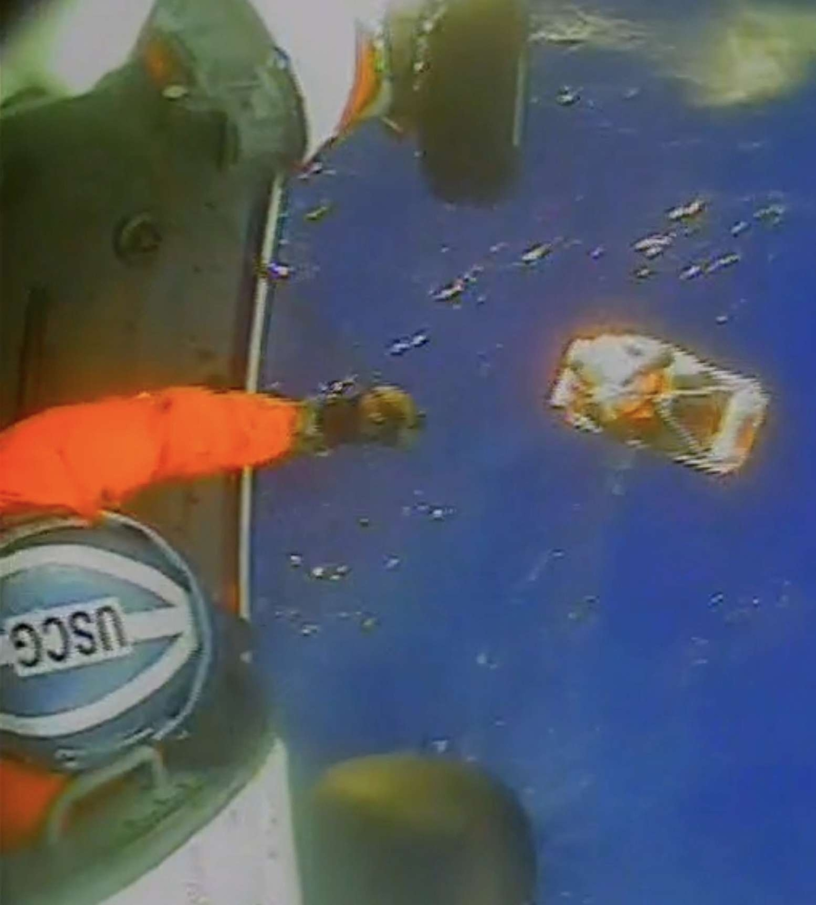 PHOTO: A member of the U.S. Coast Guard works during a rescue of four Canadians about 140 miles off the coast of North Carolina, in a still from a video released by the USCG on Oct. 22, 2023.