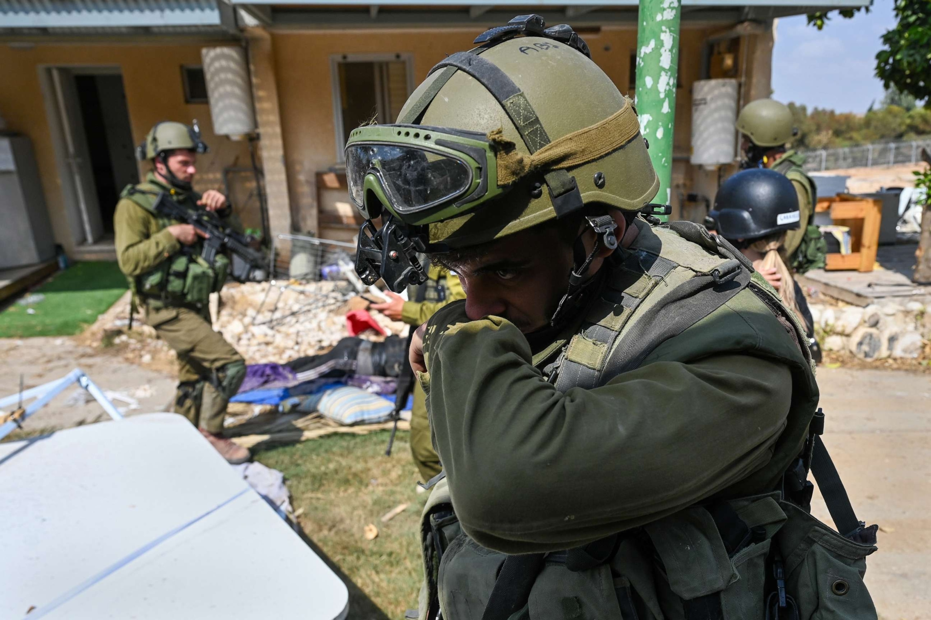 PHOTO: An IDF Soldier covers his nose while walking past Hamas militants and Israeli civilians who were killed days earlier in an attack by Hamas militants on this kibbutz near the border with Gaza, on Oct. 10, 2023 in Kfar Aza, Israel.