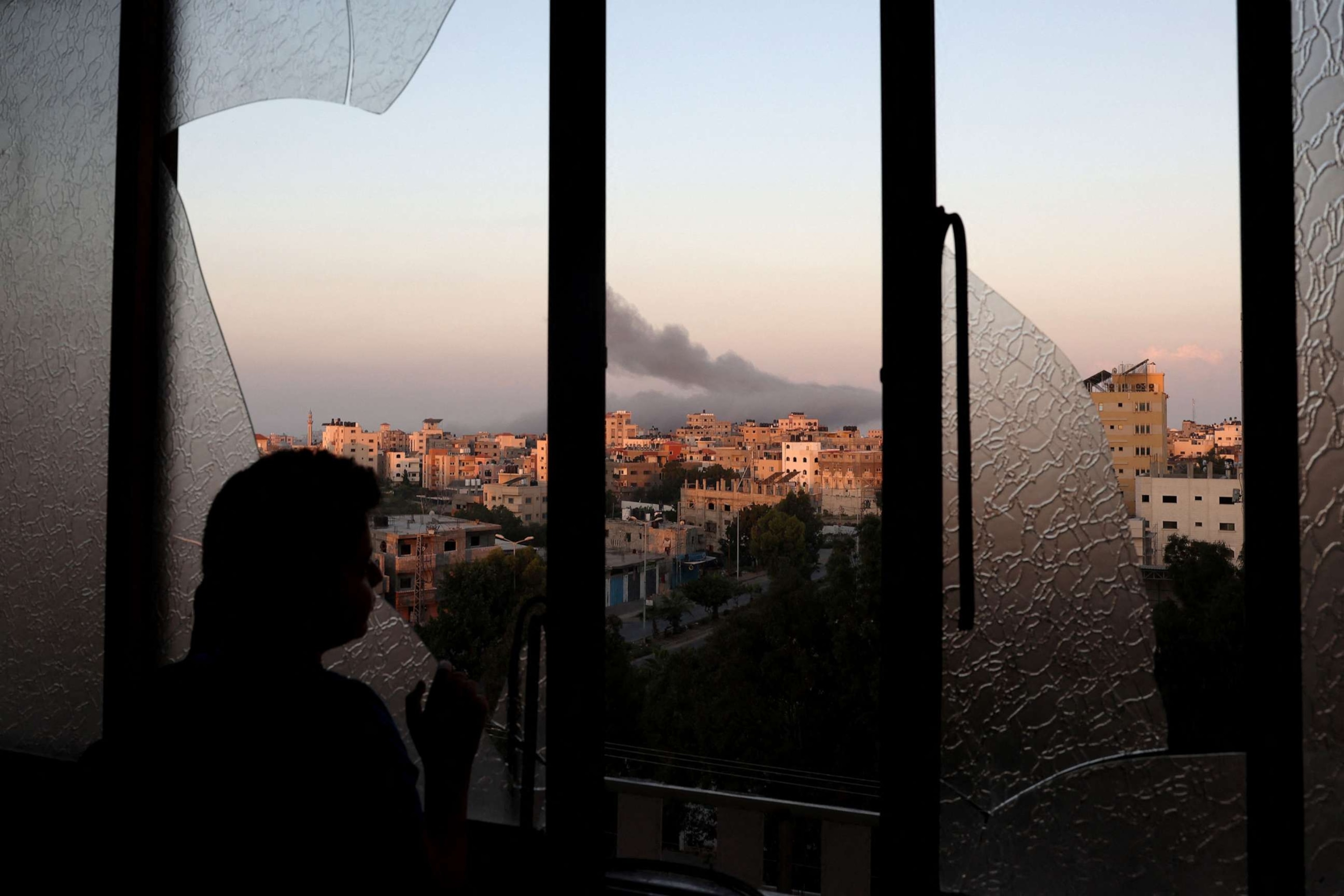 PHOTO: A Palestinian child watches as smoke billows on the horizon after an Israeli air strike in Gaza City on Oct. 13, 2023.