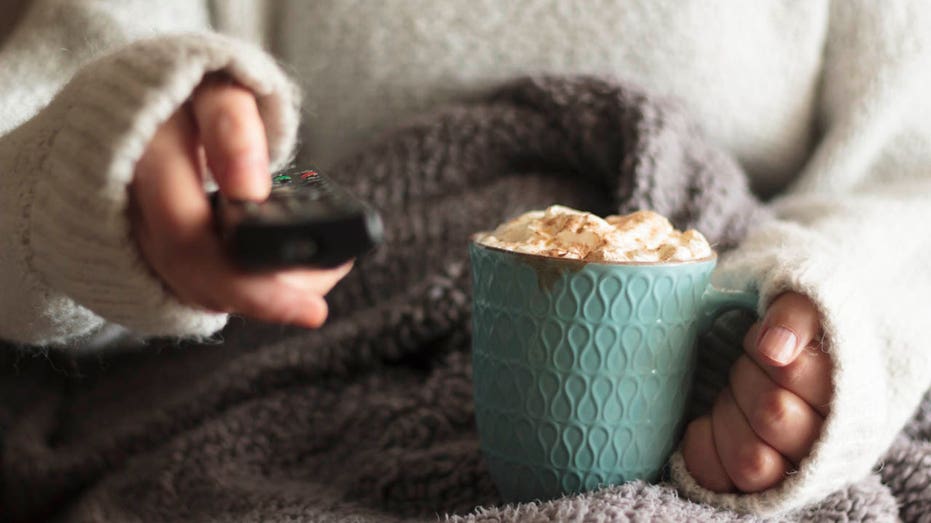 Person watching tv with drink