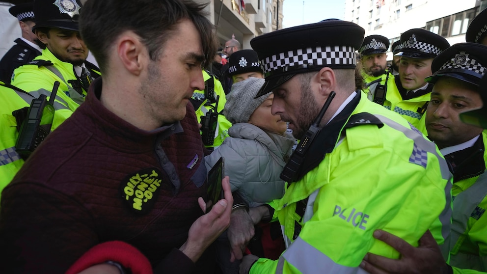 Environmental activist Greta Thunberg is taken away by police officers during the Oily Money Out protest outside the Intercontinental Hostel, in London, Tuesday, Oct. 17, 2023. (AP Photo/Kin Cheung)