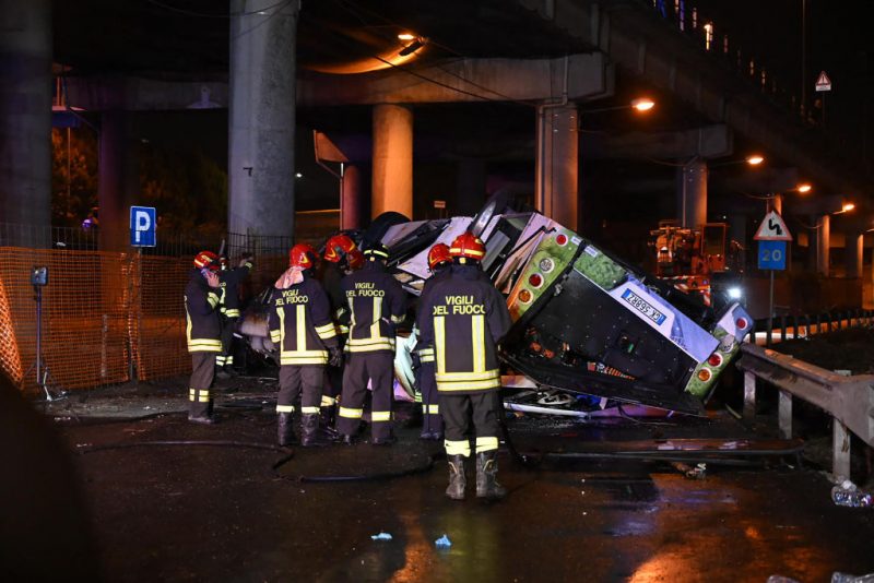 TOPSHOT - Firefighters work on the site of a bus accident on October 03, 2023 in Mestre, near Venice. At least 20 people were killed Tuesday when a bus plunged off a bridge in the northern Italian city of Venice, a city hall spokesman told AFP. The crash caused "at least 20 deaths, including two children," the spokesman said. Firefighters said the bus caught fire after careering off a bridge linking the Mestre and Marghera districts. (Photo by Marco SABADIN / AFP) (Photo by MARCO SABADIN/AFP via Getty Images)