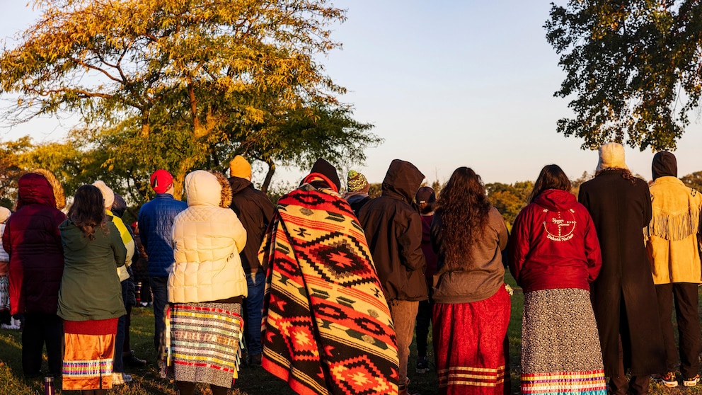People attend an Indigenous People Sunrise ceremony at Bde Maka Ska Lake in Minneapolis, Minn. on Monday, Oct. 9, 2023. (Kerem Yücel/Minnesota Public Radio via AP)