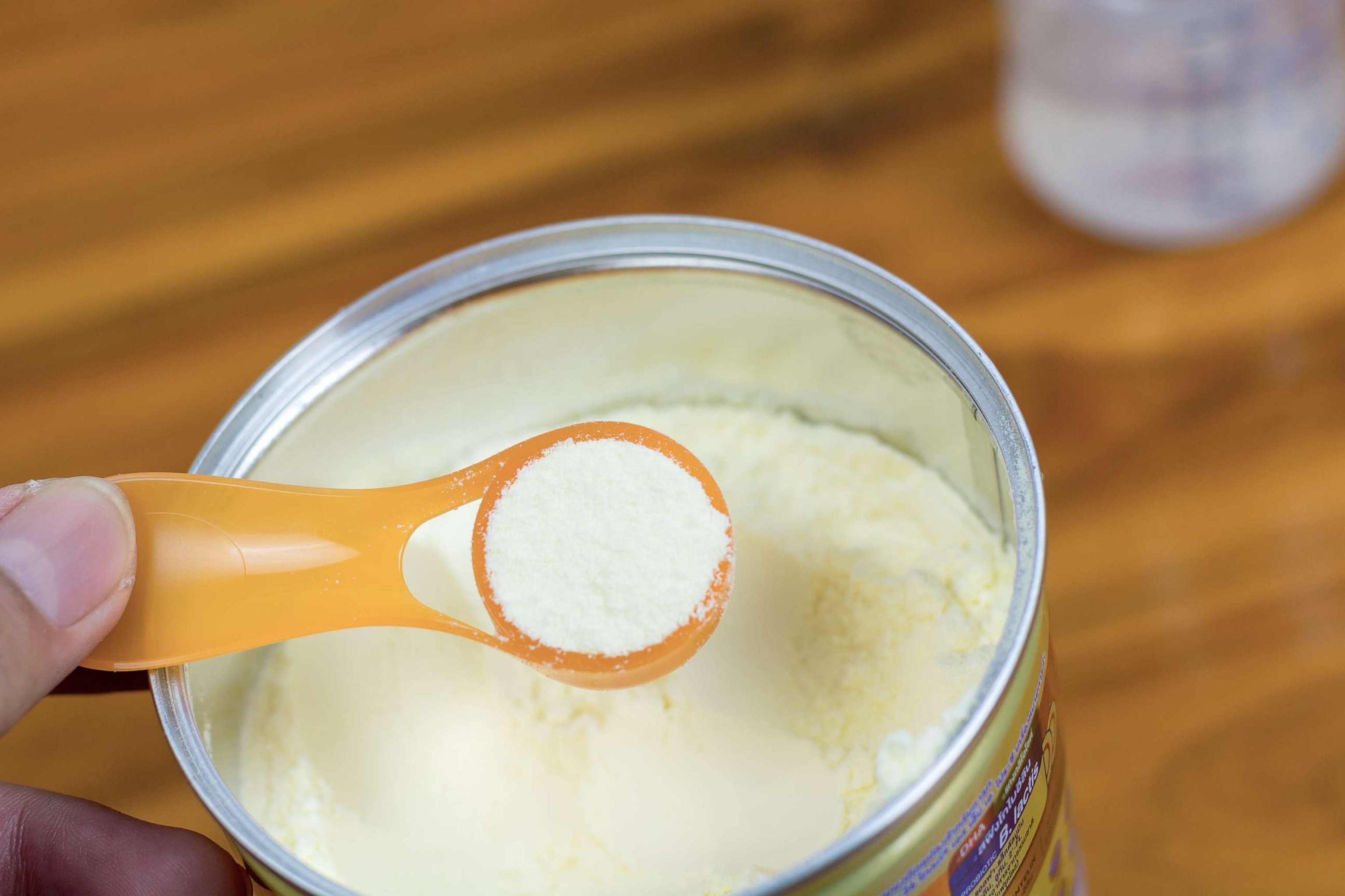 PHOTO: Powder milk and blue spoon on light background close-up. Milk powder for baby in measuring spoon on can in an undated stock photo.