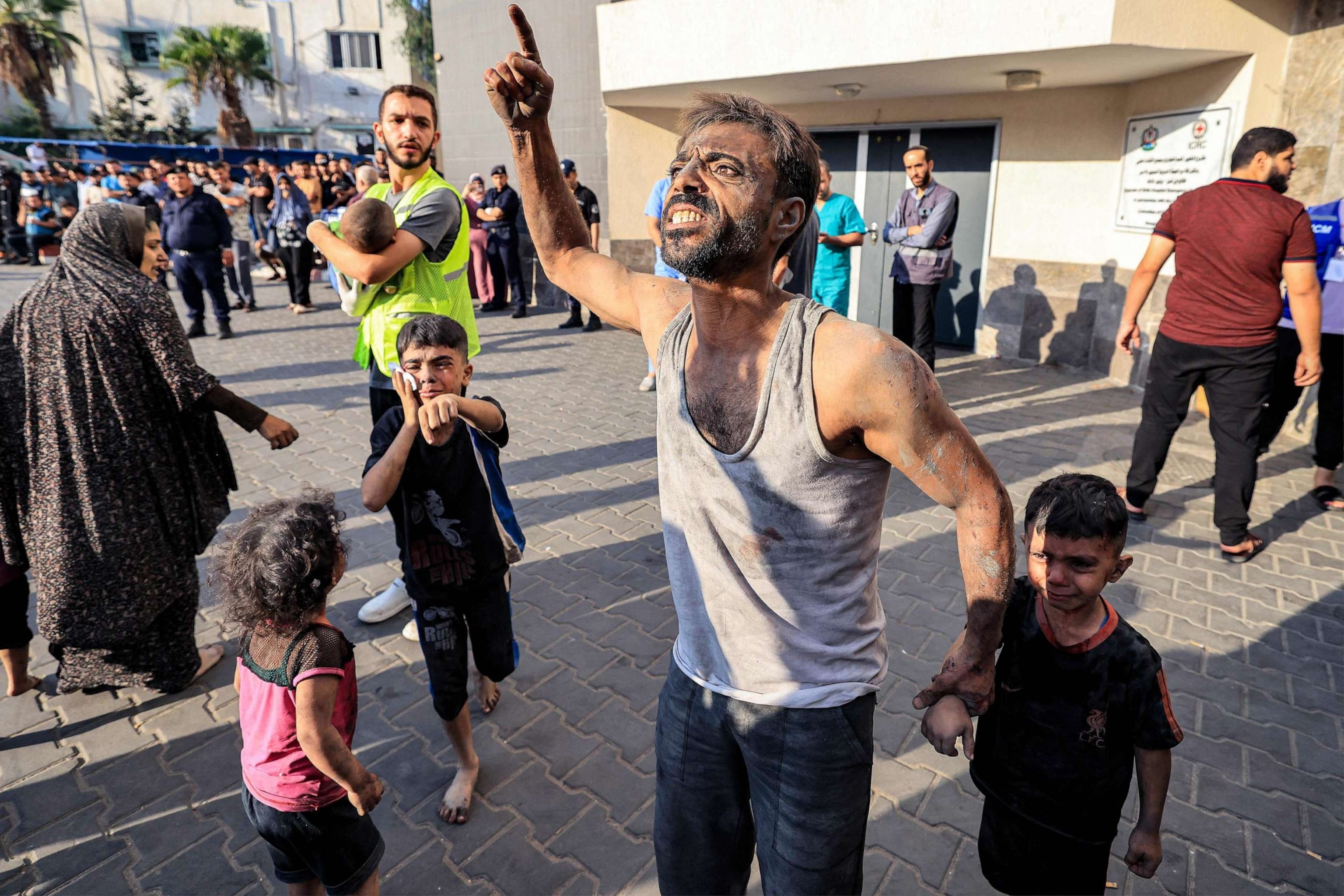PHOTO: A Palestinian man with a child reacts outside Shifa hospital in Gaza City on Oct. 12, 2023 as raging battles between Israel and the Hamas movement continue for the sixth consecutive day.