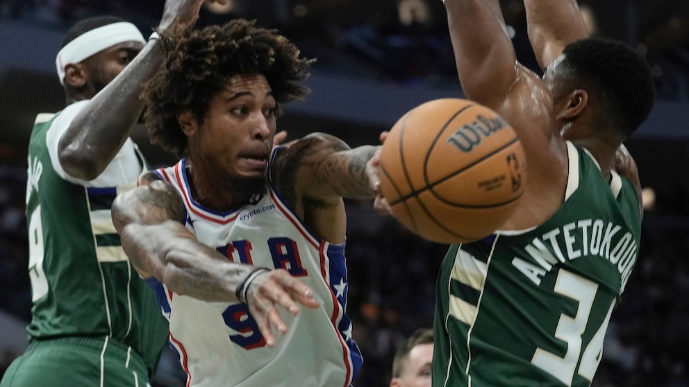 Philadelphia 76ers' Kelly Oubre Jr. asses between Milwaukee Bucks' Giannis Antetokounmpo and Bobby Portis during the first half of an NBA basketball game Thursday, Oct. 26, 2023, in Milwaukee. (AP Photo/Morry Gash)