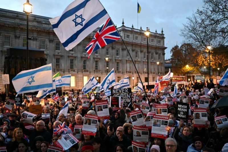 Protesters wave Israeli flags and hold photos of people held hostage by Palestinian militant group Hamas in Gaza, during a demonstration outside Downing Street on November 19, 2023 to protest against antisemitism and to call for the release of the hostages. (Photo by JUSTIN TALLIS / AFP) (Photo by JUSTIN TALLIS/AFP via Getty Images)