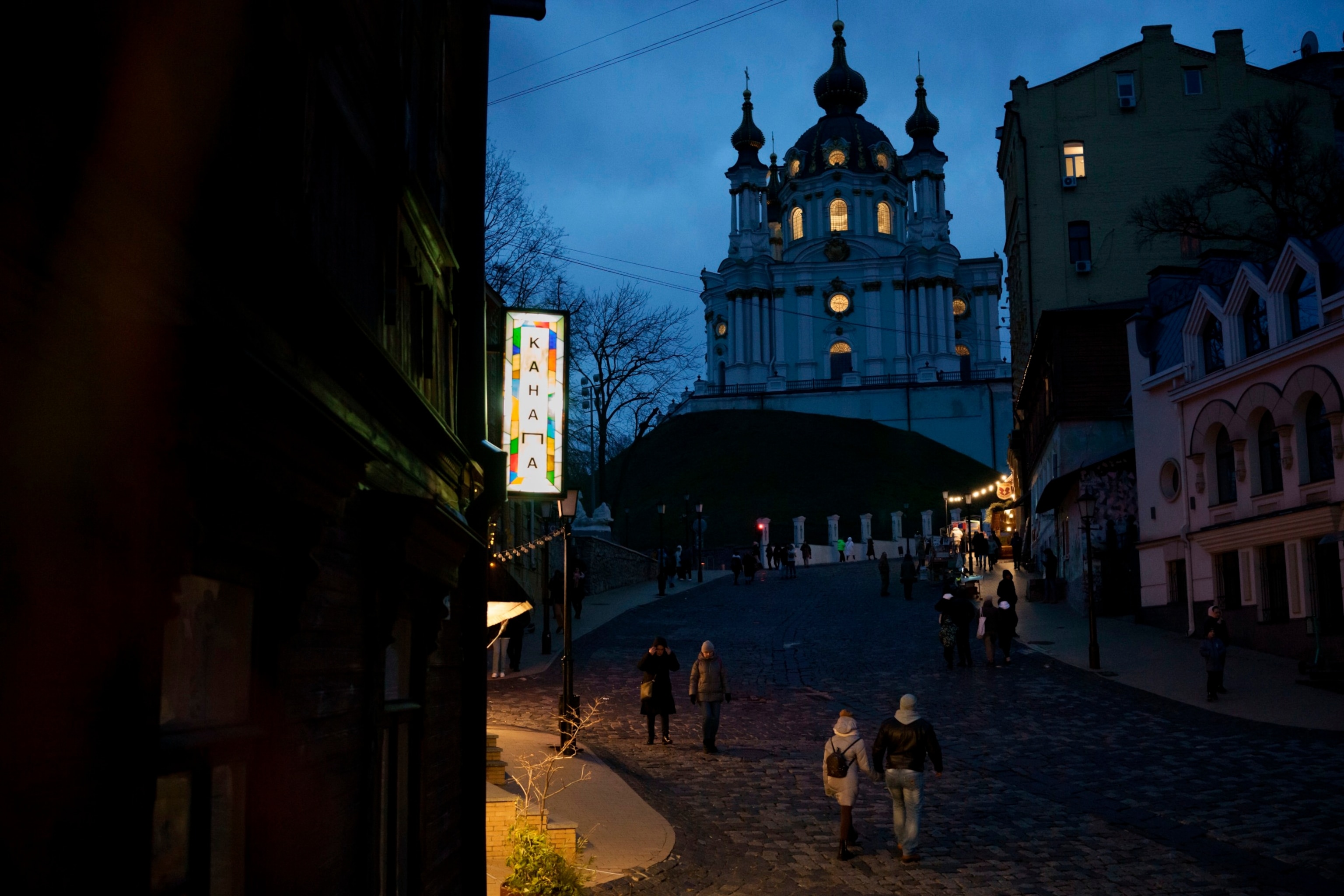 PHOTO: People walk at dusk near the St. Andrew's Church in Kyiv, Ukraine, Saturday, Nov. 18, 2023. 