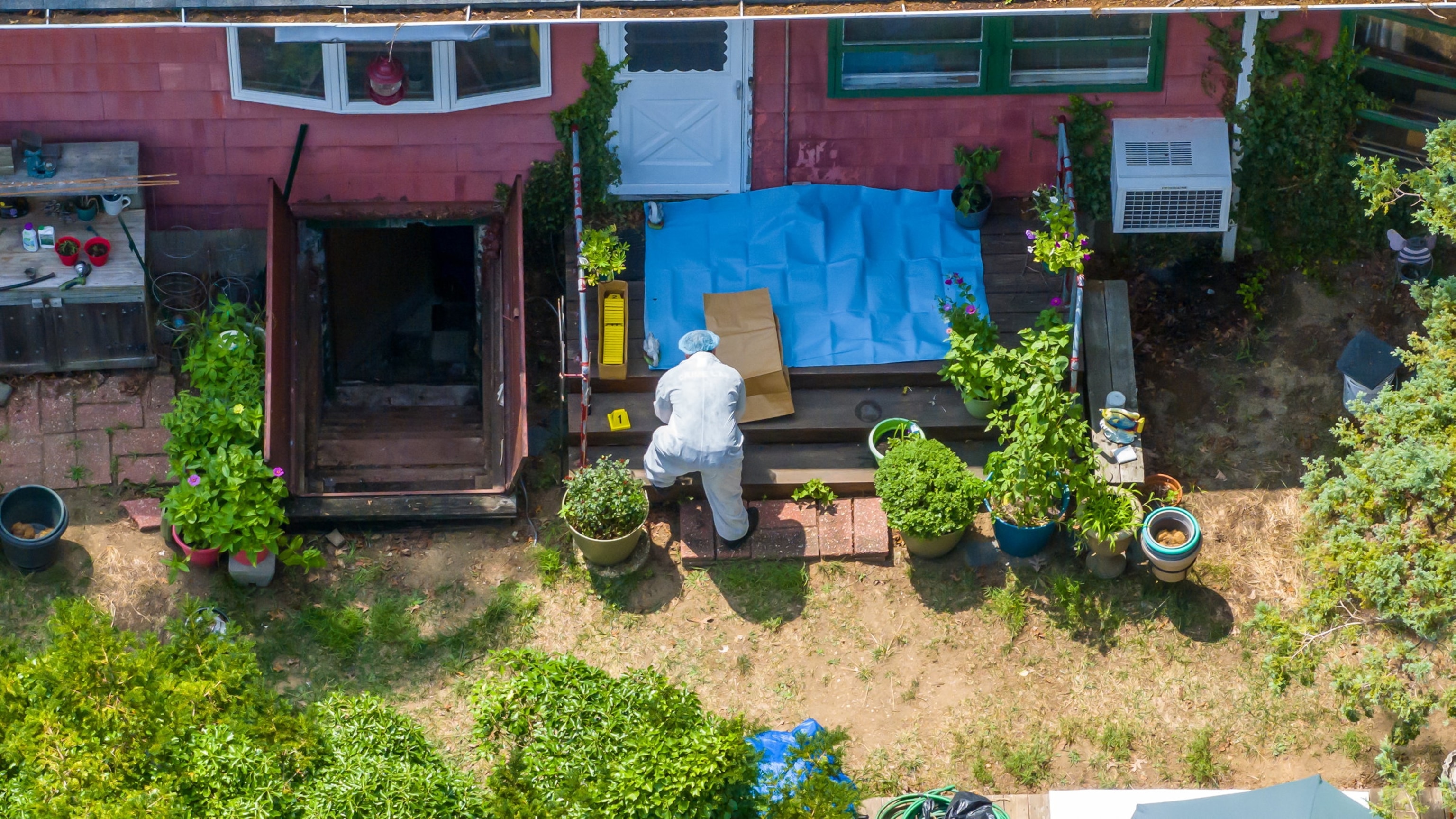 PHOTO: A police Investigator works in the backyard of Gilgo Beach murders suspect Rex Heuermann's home in Massapequa Park, New York, July 14, 2023. 