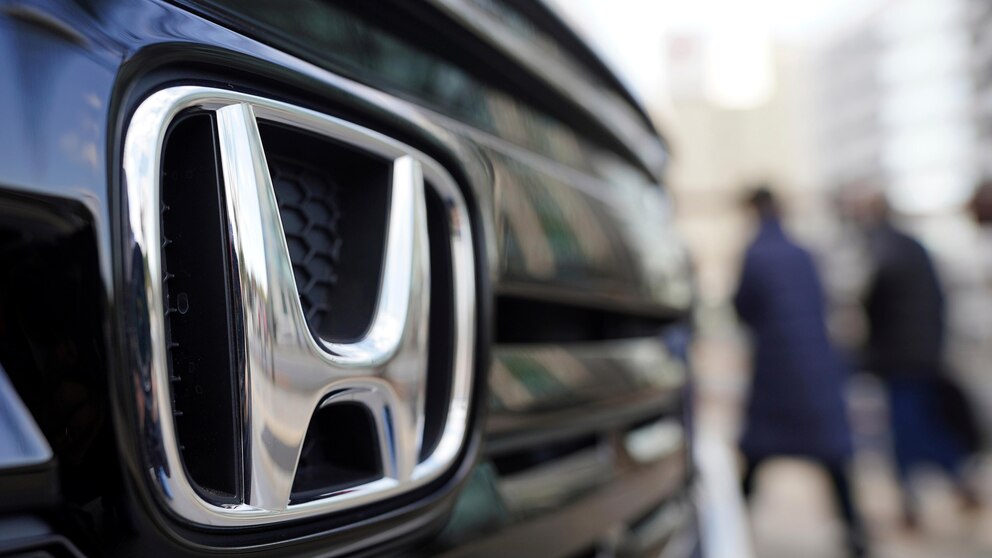 FILE - People walk near the logo of Honda Motor Company at a showroom Tuesday, Feb. 8, 2022, in Tokyo. Honda is recalling several hundred thousand 2023-2024 Accord and HR-V vehicles, Saturday, Nov. 25, 2023, due to a missing piece in the front seat belt pretensioners, which could increase injury risks during a crash. (AP Photo/Eugene Hoshiko, File)