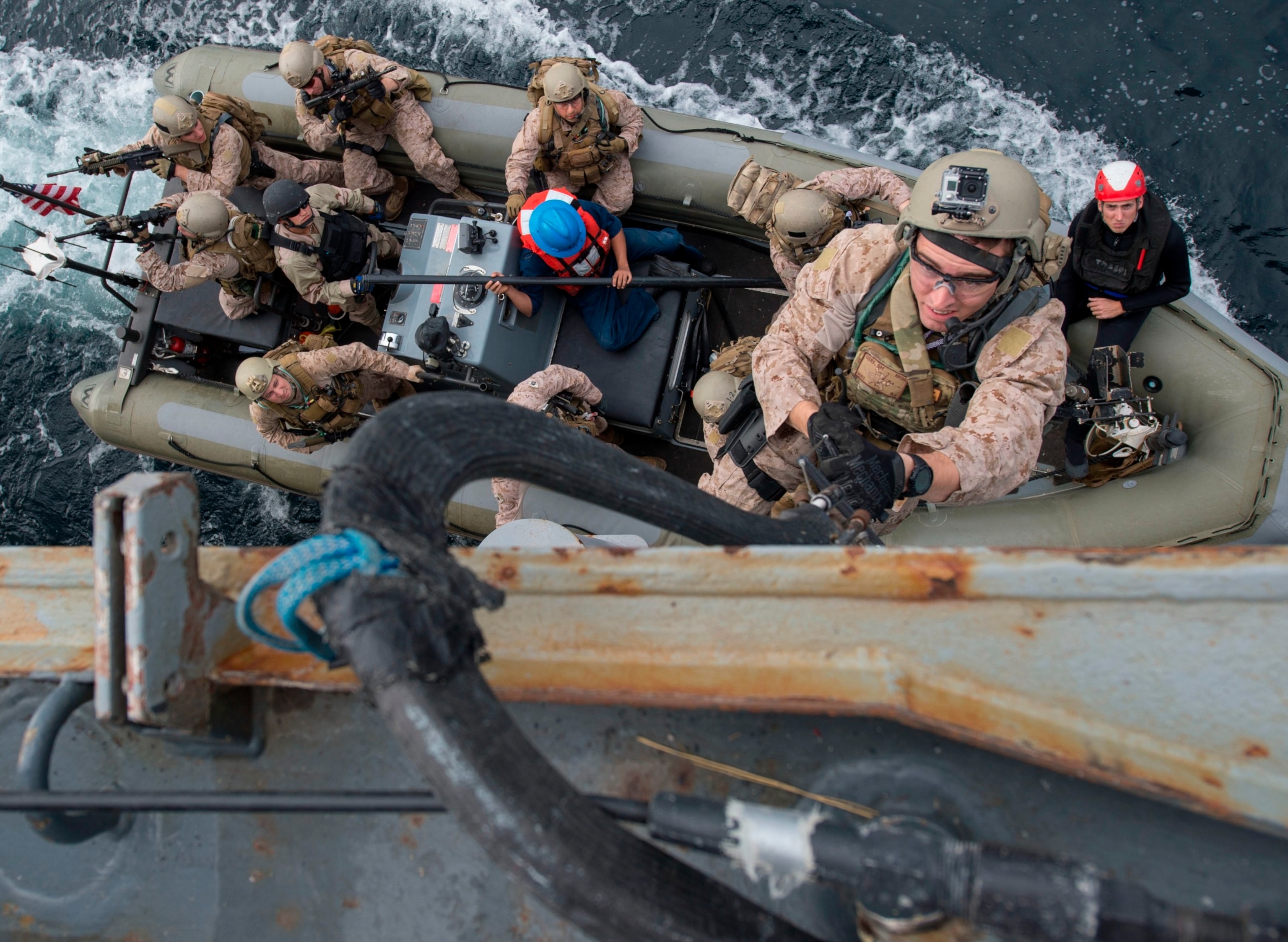 PHOTO: Marines assigned to the 13th Marine Expeditionary Unit embarked aboard the amphibious assault ship USS Boxer climb aboard the guided-missile destroyer USS Mason from a rigid-hull inflatable boat during a visit, board, search and seizure exercise. 