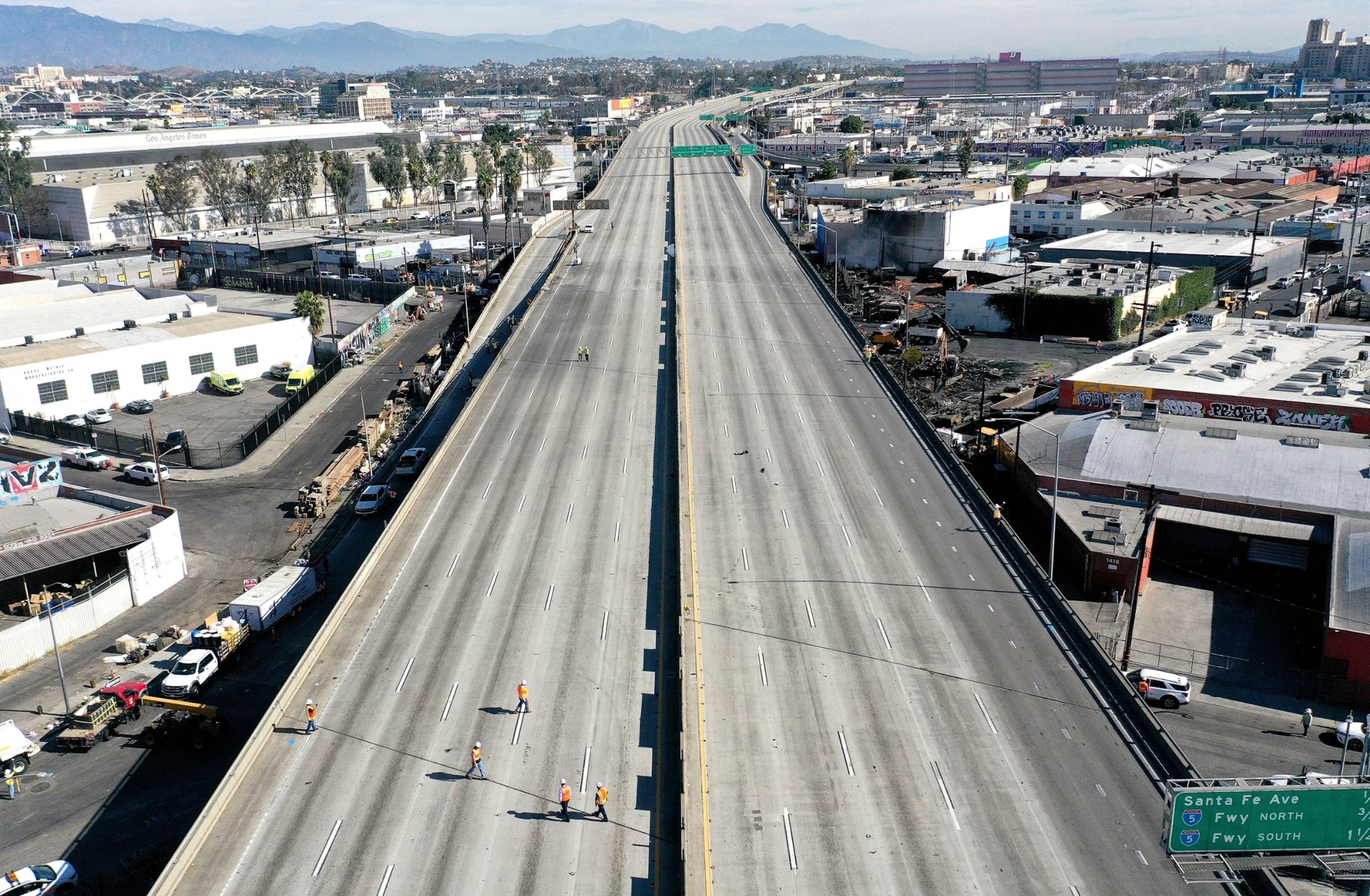 PHOTO: An aerial view of workers walking on the closed I-10 freeway following a large pallet fire, which occurred Saturday at a storage yard, on Nov. 13, 2023 in Los Angeles.