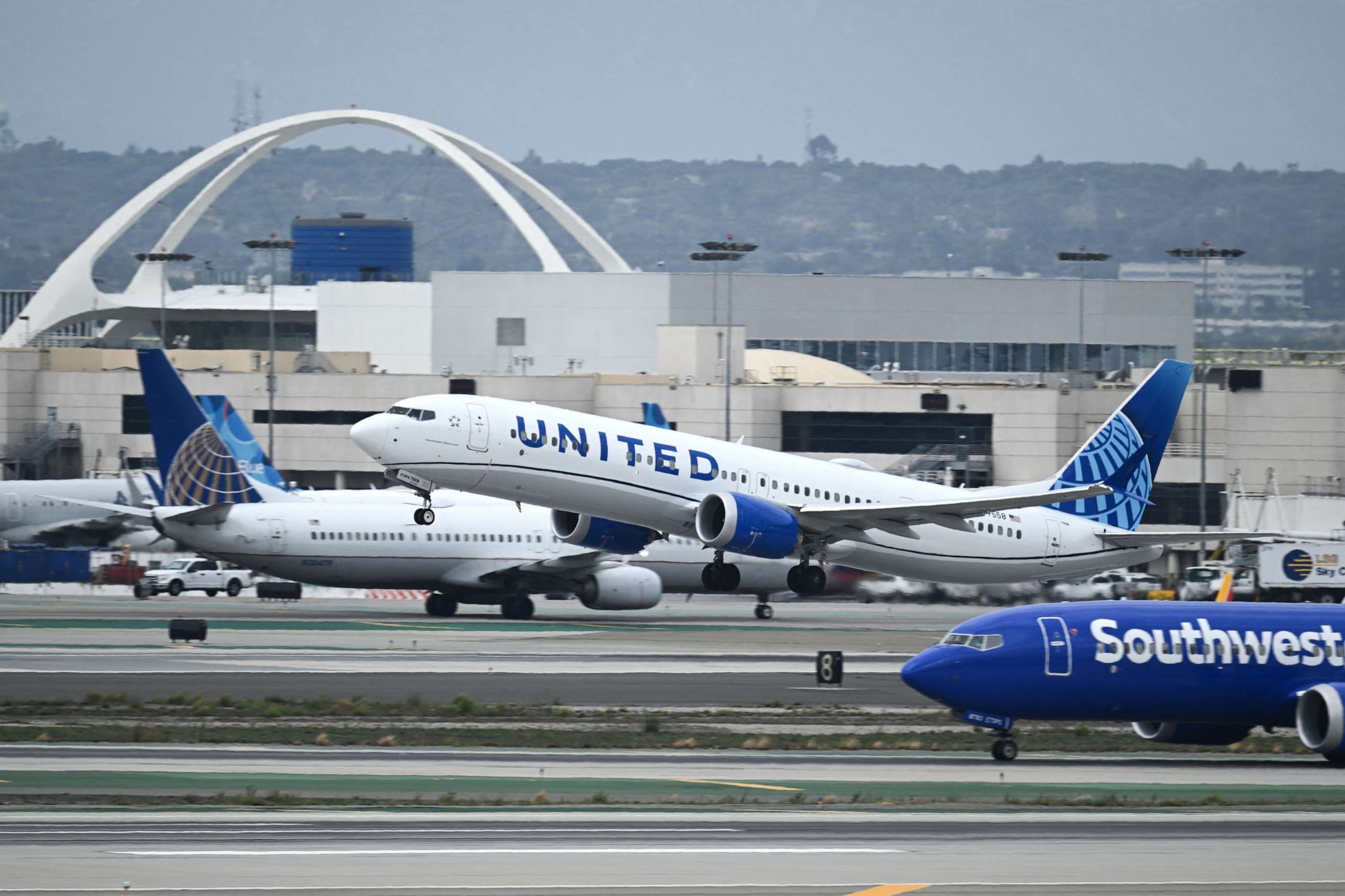 PHOTO: A United Airlines Boeing 737 MAX 9 airplane passes a Southwest Airlines Boeing 737 while taking off from Los Angeles International Airport (LAX) as seen from El Segundo, California, on September 11, 2023.