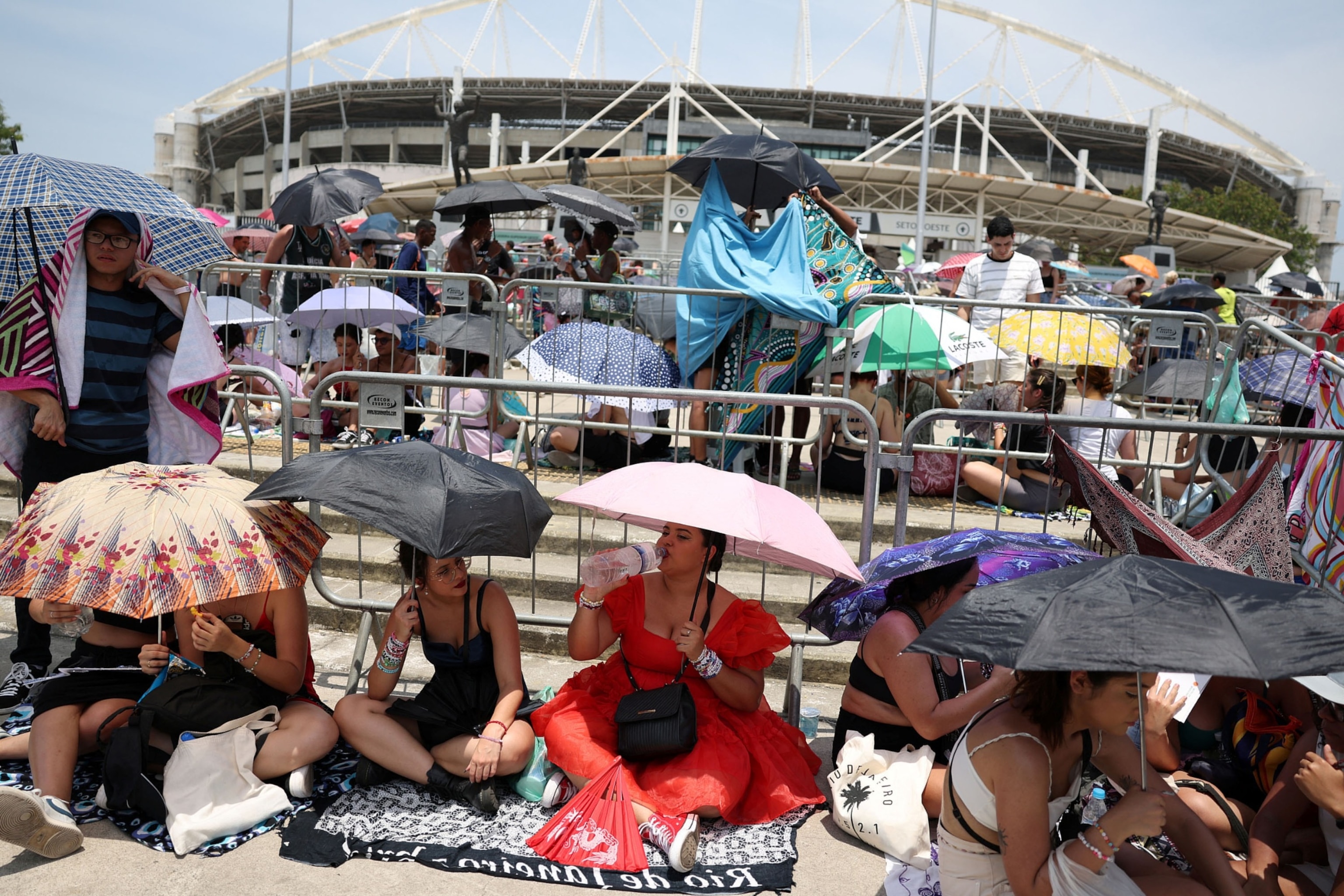 PHOTO: People holding umbrellas wait for the Taylor Swift concert, following the death of a fan due to the heat during the first day concert, in Rio de Janeiro, Brazil, on Nov. 18, 2023. 
