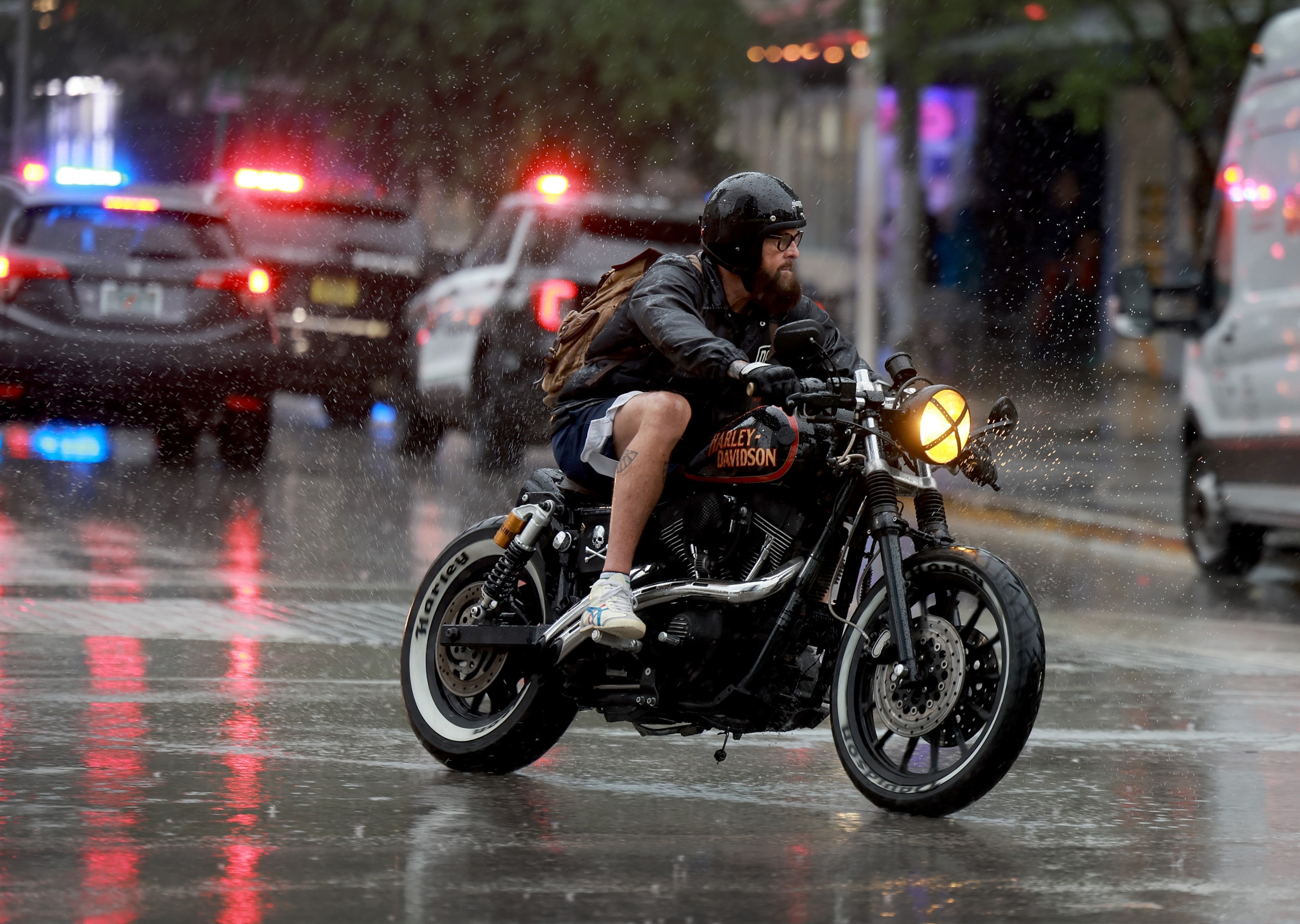 PHOTO: A motorcyclist drives through a rain storm on November 15, 2023 in Miami Beach, Florida.