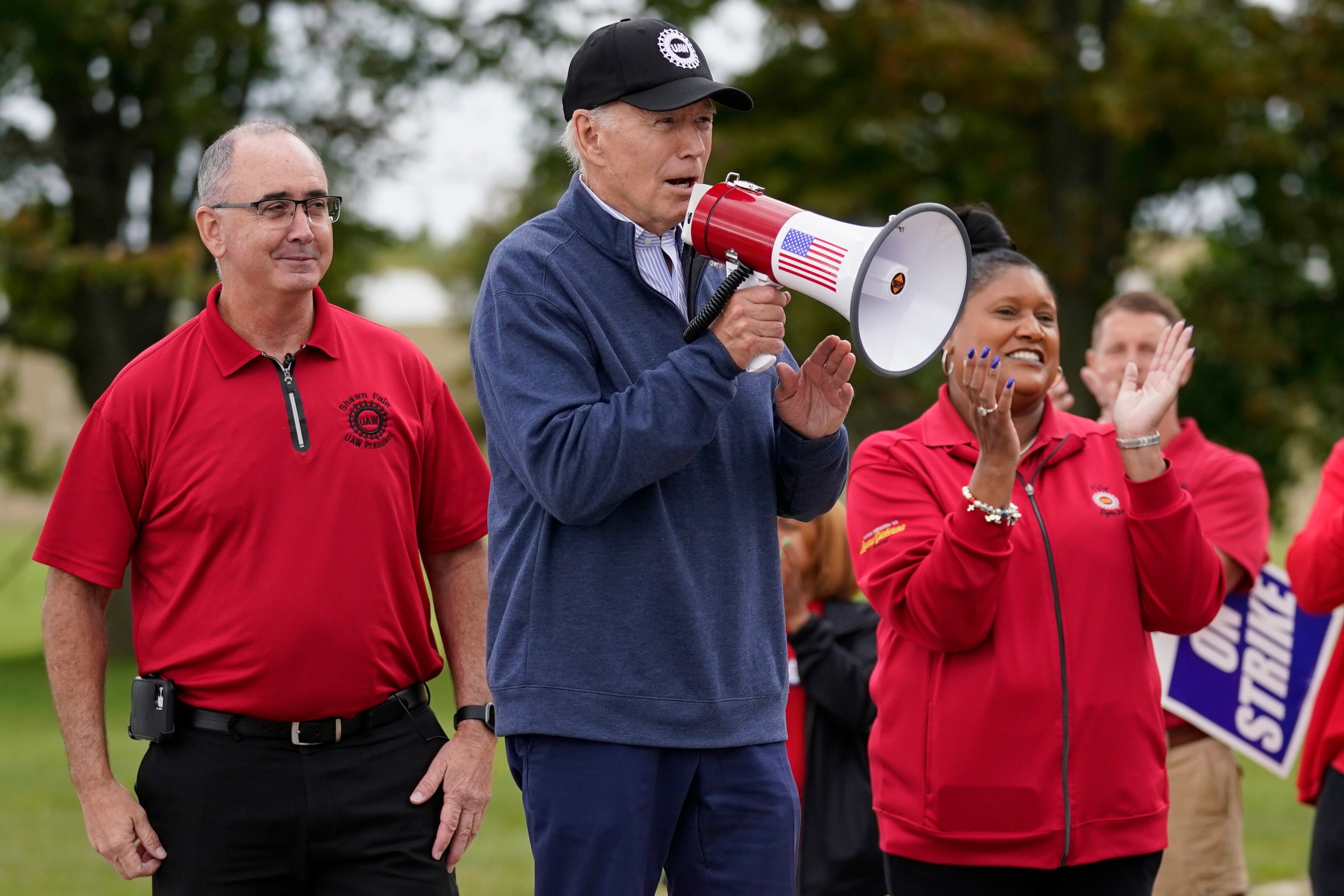 PHOTO: President Joe Biden speaks as he joins striking United Auto Workers on the picket line, Tuesday, Sept. 26, 2023, in Van Buren Township, Mich. United Auto Workers President Shawn Fain listens at left. 