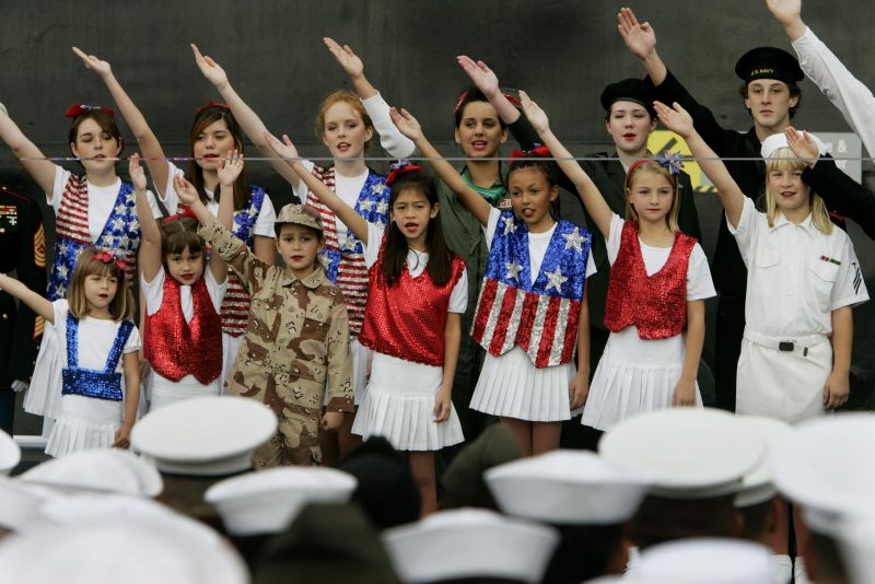 Military Personnel Sworn In As Citizens Aboard USS Midway On Veterans Day SAN DIEGO, CA - NOVEMBER11: Children from Celebration USA, Catch the Spirit Singers, perform during a military naturalization ceremony for U.S. Navy Sailors and U.S. Marines aboard the USS Midway November 11, 2005 in San Diego, California. More than 100 military personel from 48 countries became citizens during the naturalization ceremony. (Photo by Sandy Huffaker/Getty Images)