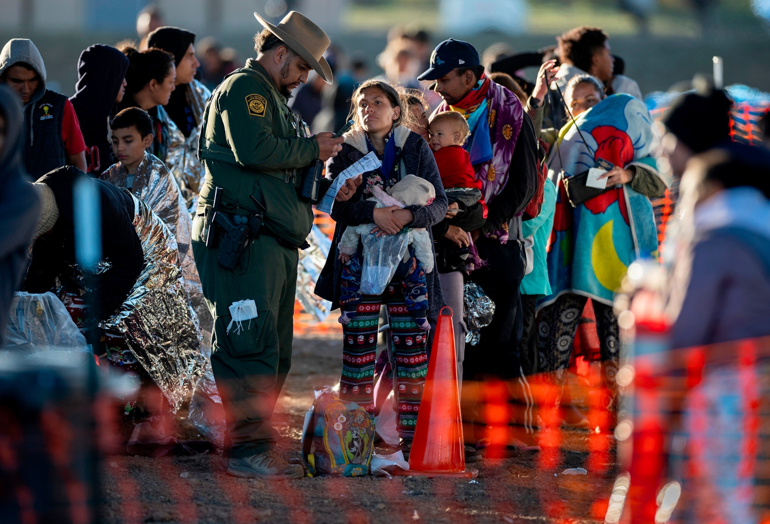 PHOTO: A U.S. Border Patrol agent speaks with immigrants at a transit center near the U.S.-Mexico border on, Dec. 19, 2023, in Eagle Pass, Texas. 